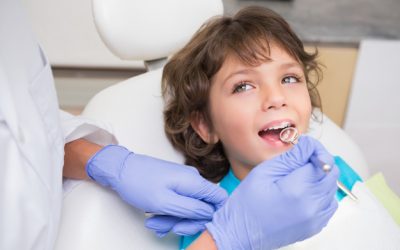 dentista-pediatrico-examinando-dientes-nino-pequeno-silla-dentistas_13339-298672